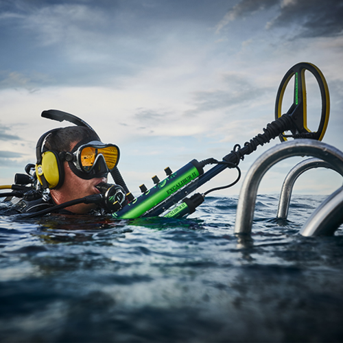 Diver in water with Minelab Excalibur 2 underwater detector.